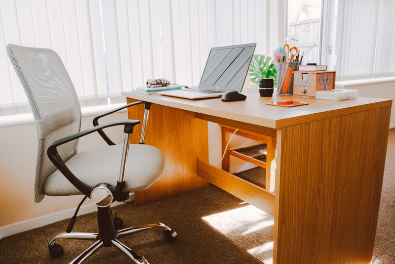 Wiping down an office desk during a commercial clean